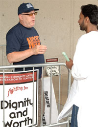 Nassau CCFT member Richard Newman, left, discusses the union's concerns with graduating student Ghouse Hameed.
