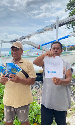 Fisherman in Bali holding brochures