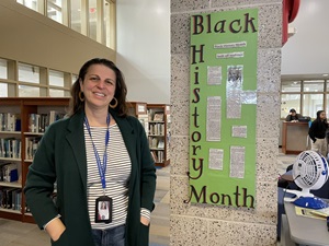 Librarian standing in front of Black History Month poster
