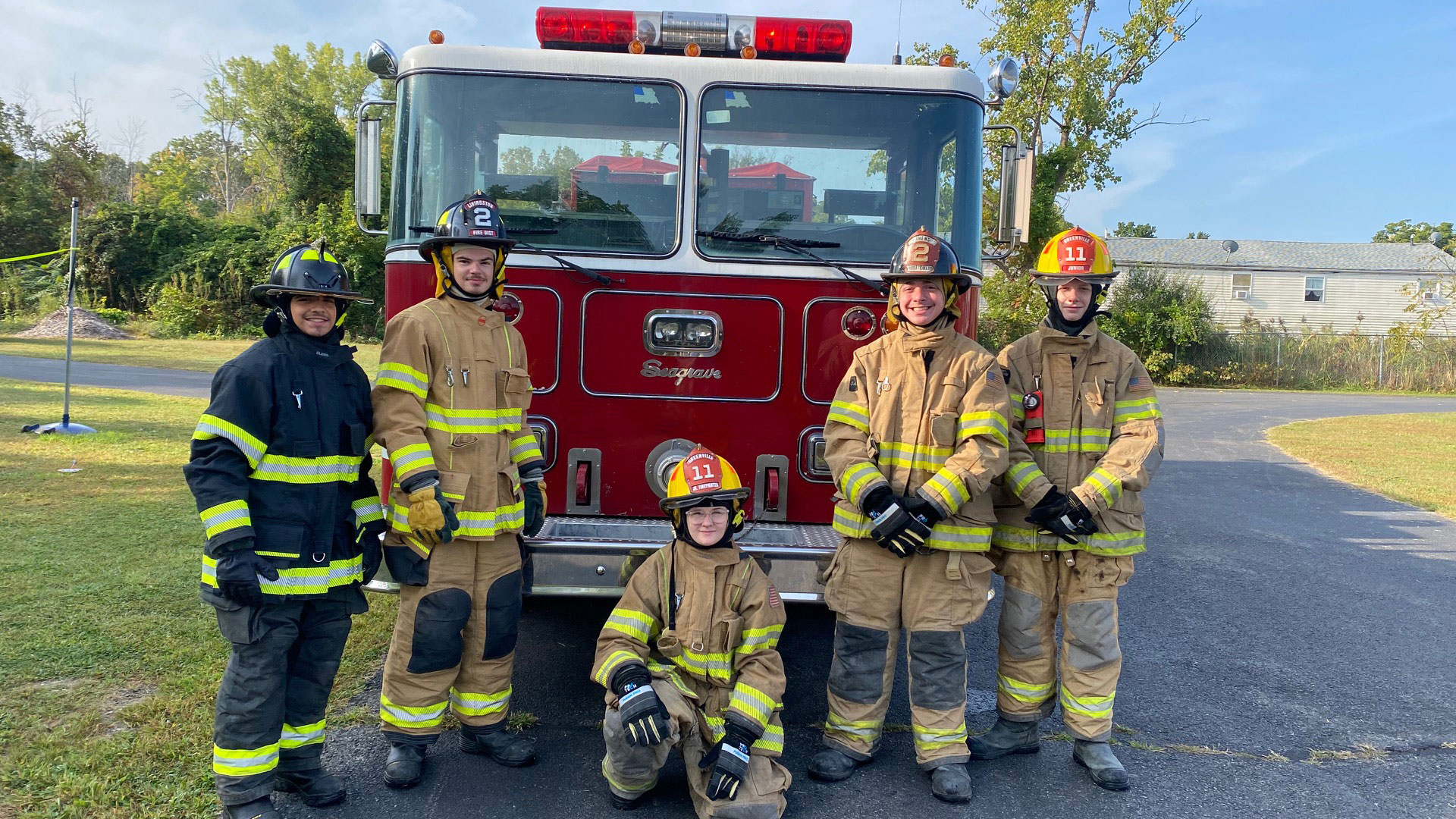 Group of firefighters standing in front of a fire truck