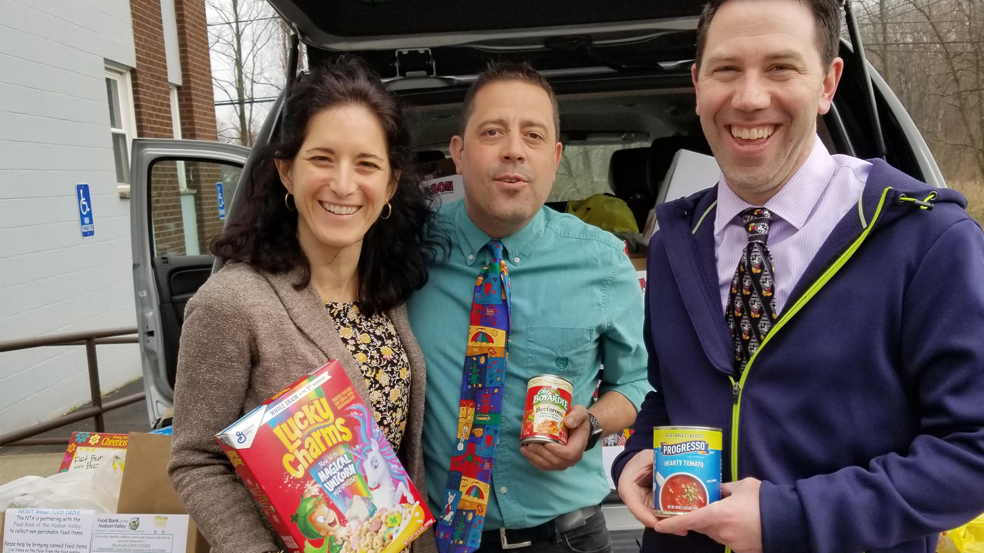 Group of teachers holding food from a food drive