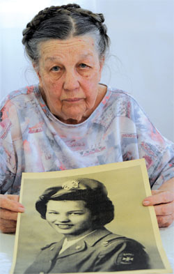 Anne Kakos holds a photo of herself as a Cadet Nurse during World War II.