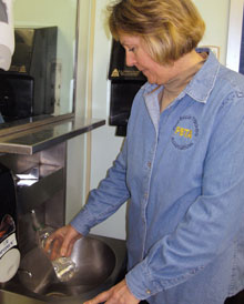 Judy Muller, Pine Bush TA vice president and head of the union's health and safety committee, takes samples of tapwater for testing. 