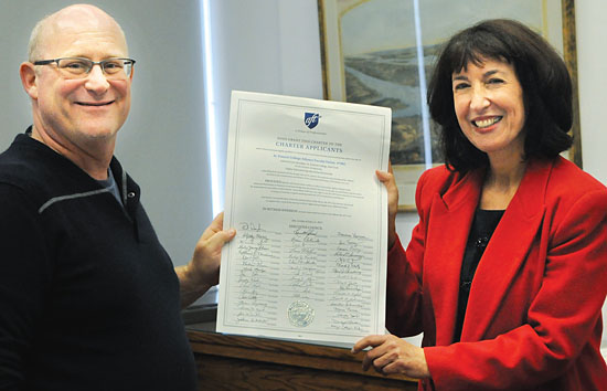 Judy Sandler, a NYSUT labor relations specialist, presents Howard Skrill, interim treasurer of St. Francis College Adjunct Faculty Union, with the new unit’s charter.