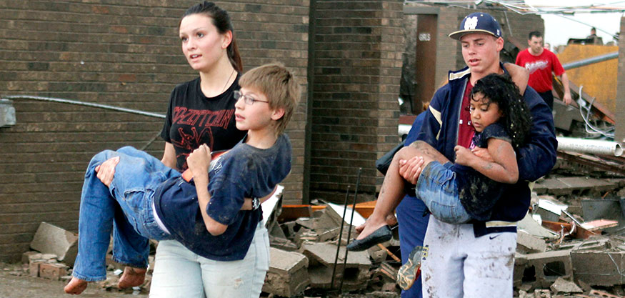 Teachers carry children away from Briarwood Elementary school after a tornado destroyed the school in south Oklahoma City, Okla, Monday, May 20, 2013. Near SW 149th and Hudson. (AP Photo/ The Oklahoman, Paul Hellstern)