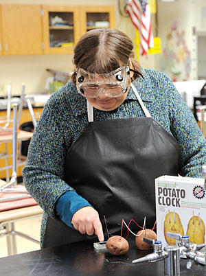 Science teacher Rose Hochmuth, a member of the Schalmont TA, shows how to operate a clock using wires and a potato.
