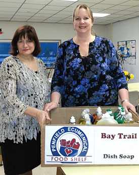 Penfield teachers Chris McGovern and Sue Mietus prepare items for donation to the food shelf.