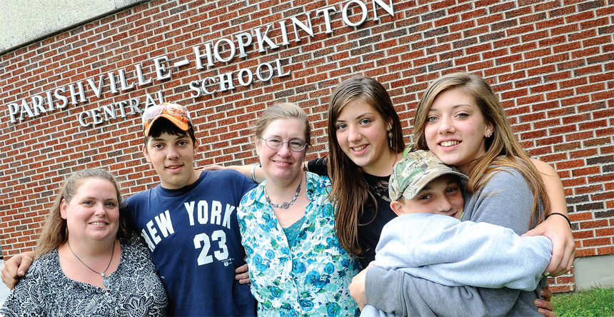 Parishville-Hopkinton guidance secretary Geri Lynn Wilson, left, and school counselor Melissa Scudder, center, both NYSUT members, came to the aid of the Wieczorek family, including, from left, Brandon, Angel, Ken Jr. and Desiree. Wilson and Scudder rallied the community to help the family find a place to live before winter set in. Photo by Steve Jacobs.