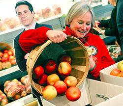 Joy Martin, a literacy coach and president of the Geneva Teachers Association, helps box up apples. The fruit is being sent to Gov. Cuomo in an effort to draw attention to the Finger Lakes region. Union leaders want promised funding back for schools. Photo by Lauren Long.