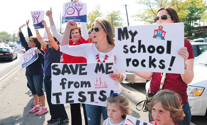 Jackie Geller, center, a parent and teacher in the Bellmore-Merrick School District, rallies with her daughter during a Reclaim the Joy demonstration along Sunrise Highway in Massapequa.