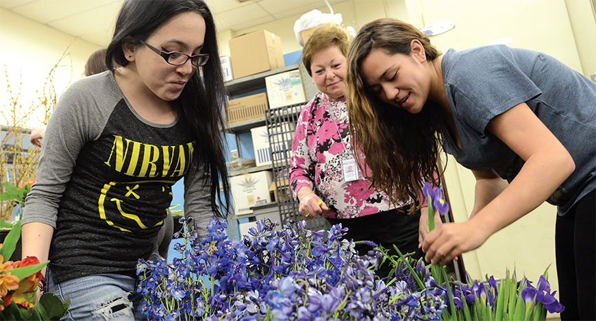 Capital Region BOCES teacher Meg Bugler, center, and students Cheyenne Butler, left, and Emma McGivern pick out flowers to make arrangements. Photo by El-Wise Noisette.