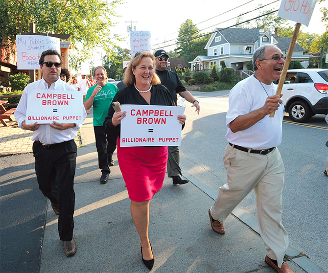 By land, sea and by air hundreds of teachers, parents and advocates are led by NYSUT officers, above, Paul Pecorale, Karen E. Magee and Andy Pallotta, and AQE to protest Campbell Brown’s appearance at the Business Council of New York State’s annual conference at the Sagamore Resort in Bolton Landing. At left, sign-laden boats honk horns while a plane circles overhead with a banner: “Campbell Brown: #Bad4Schools.” Photo by El-Wise Noisette.