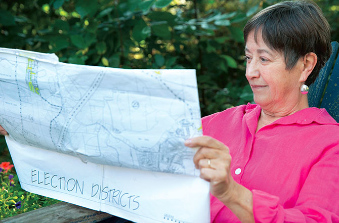 Retired teacher Janet Wheile checks a map outlining election districts in Saratoga County. Photo by Marty Kerins Jr.