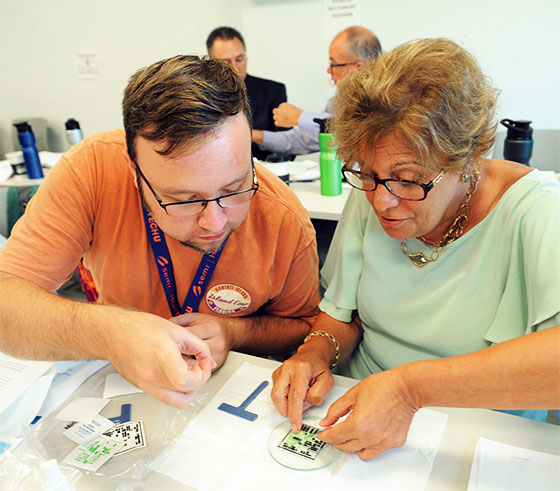 Jared Foro, a midde and high school science teacher and member of the Northville Teachers Association, works with NYSUT Vice President Catalina Fortino to create a semiconductor wafer during the SEMI High Tech U Teacher Edition workshop, sponsored by NYSUT and hosted by the TEC SMART facility in Saratoga County.