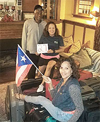 Members of the Mohonasen TA, led by Maria Pacheco, holding sign, below, rallied on short notice and packed food, diapers, wipes, batteries and flashlights to fill some of the 27 suitcases bound for Puerto Rico.