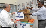 NYSUT President Andy Pallotta and First Vice President J. Philippe Abraham prepare to load supplies donated for disaster relief.