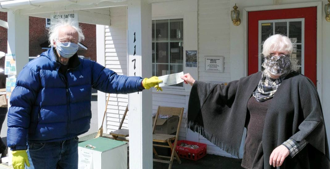Lake Placid Education Association Co-President, Kathy Brigg hands a check to Don Morrison,  head of the Wilmington Food Pantry. Photo provided.