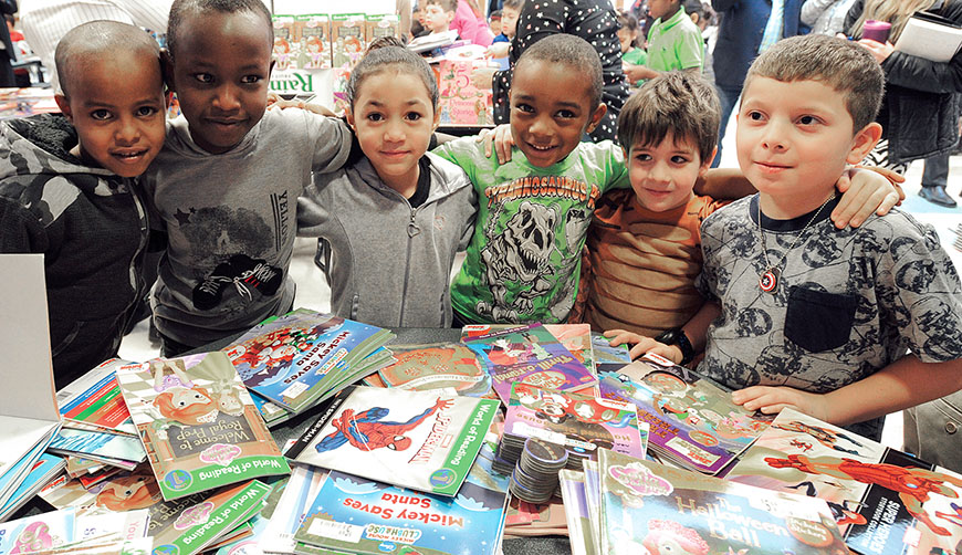 Students at Frazer Pre-K–8 School in Syracuse receive their First Books in a December giveway for the holidays. More than 2,000 books were distributed. Photo by El-Wise Noisette.
